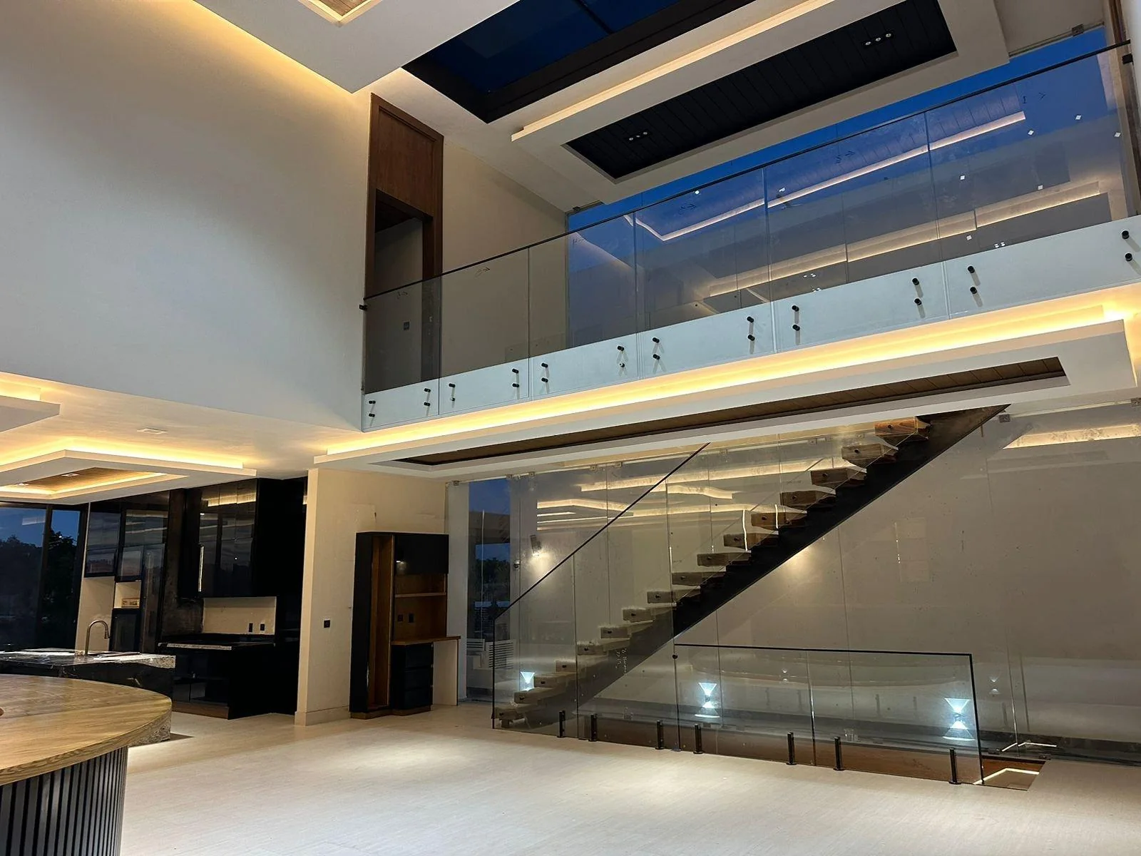 Glass railings on a staircase and mezzanine seen at night