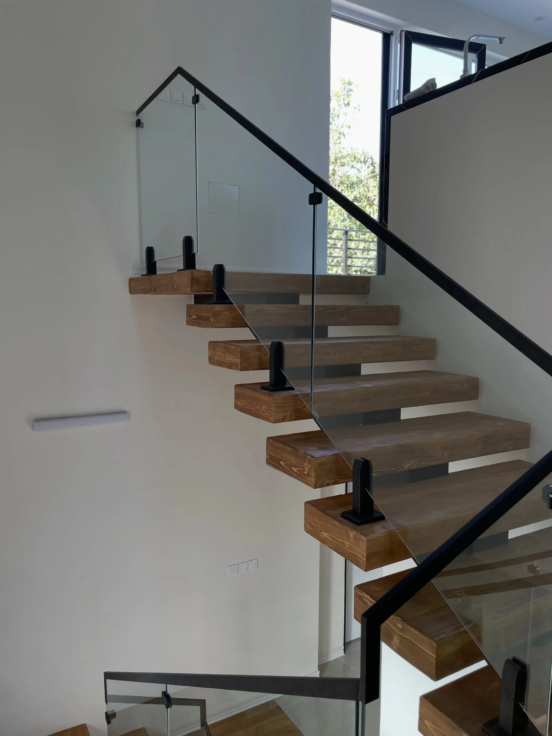 Floating treads behind a single glass panel