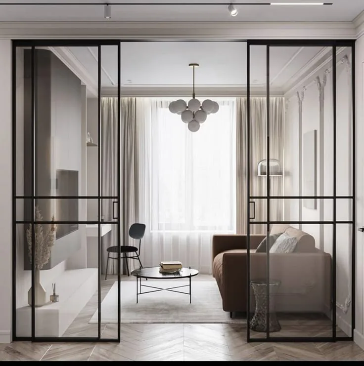 Black-framed glass doors between a living room and an adjoining room