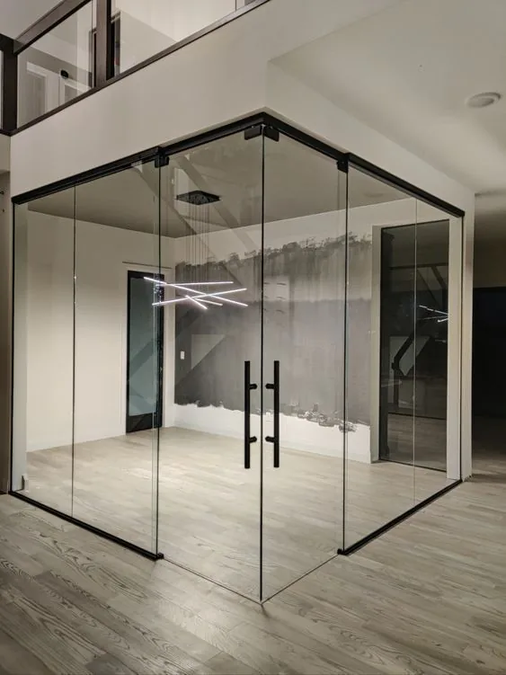 A frameless glass room with black hardware