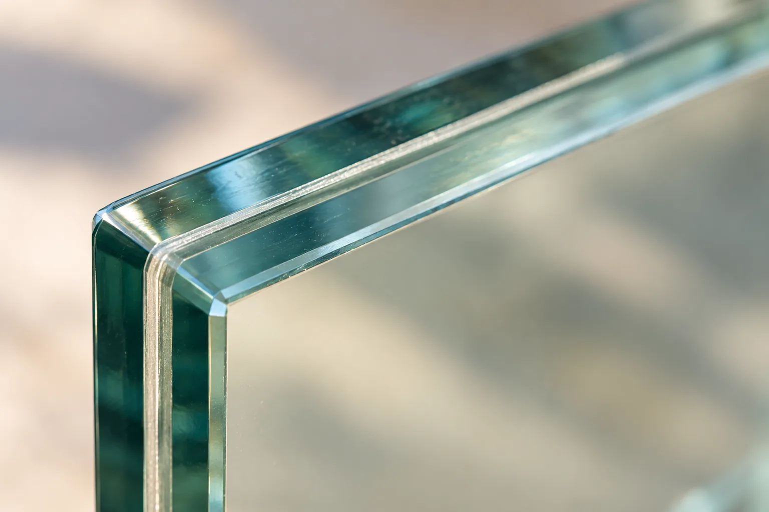 The corner of a laminated glass panel in close view, the interlayer visible as a thin line between two plies