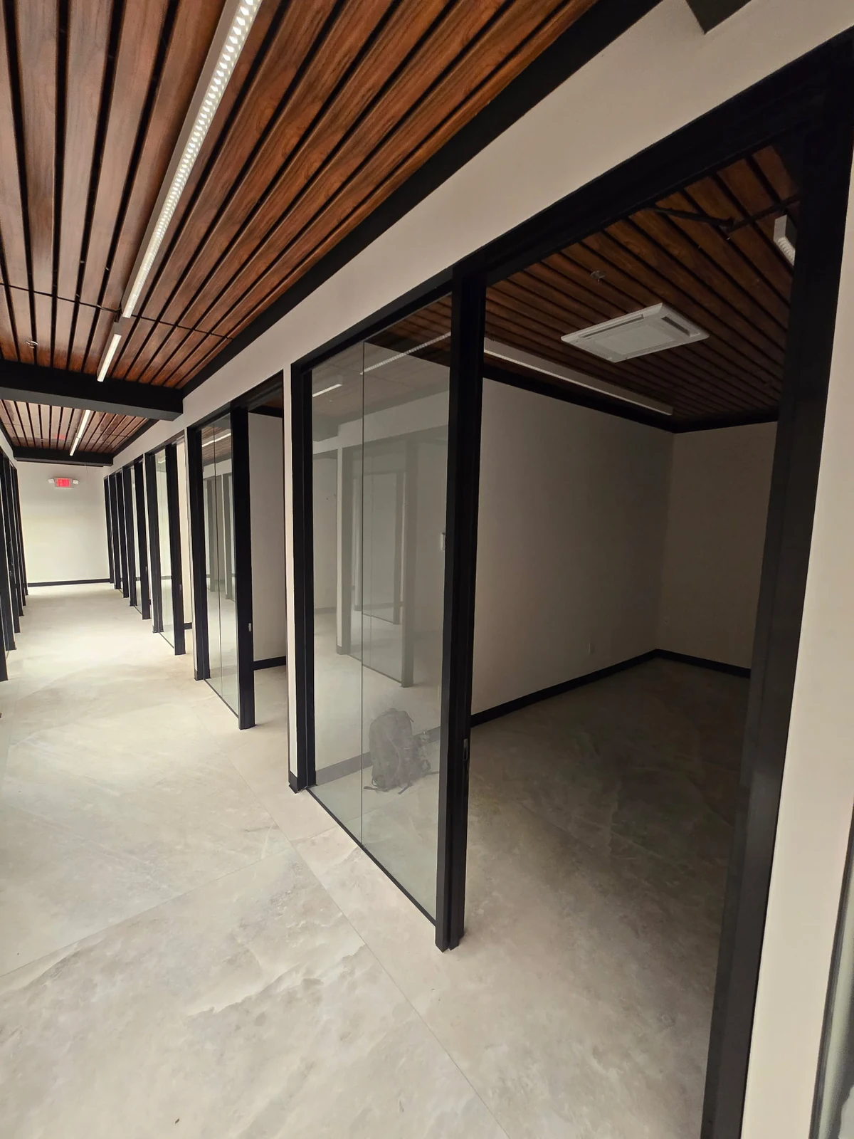 Glass offices beneath a slatted wood ceiling