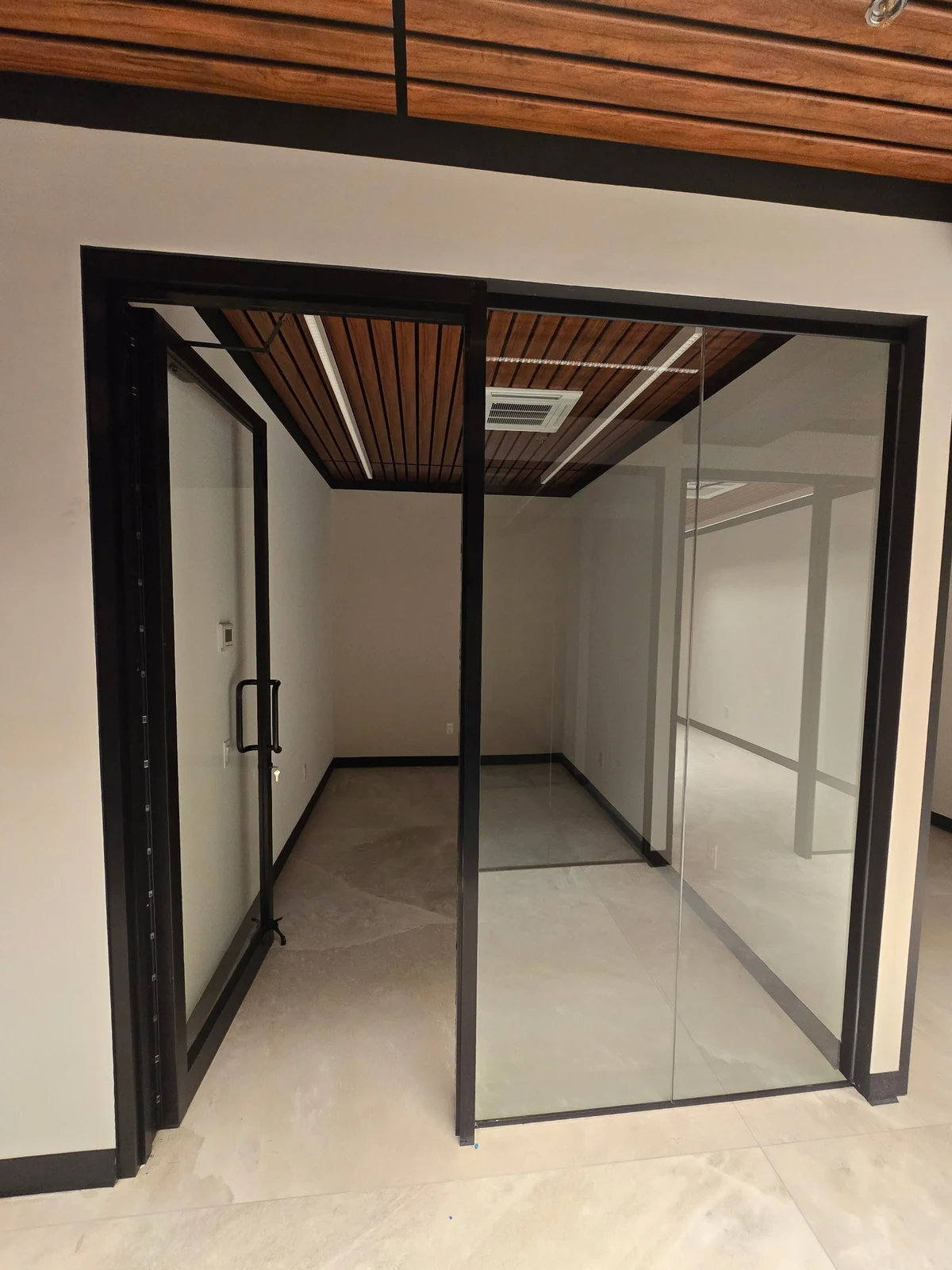 A framed glass office with a swing door