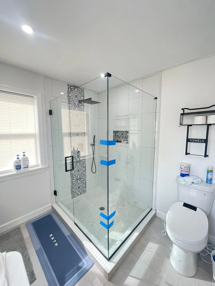 A corner shower enclosure on a low curb