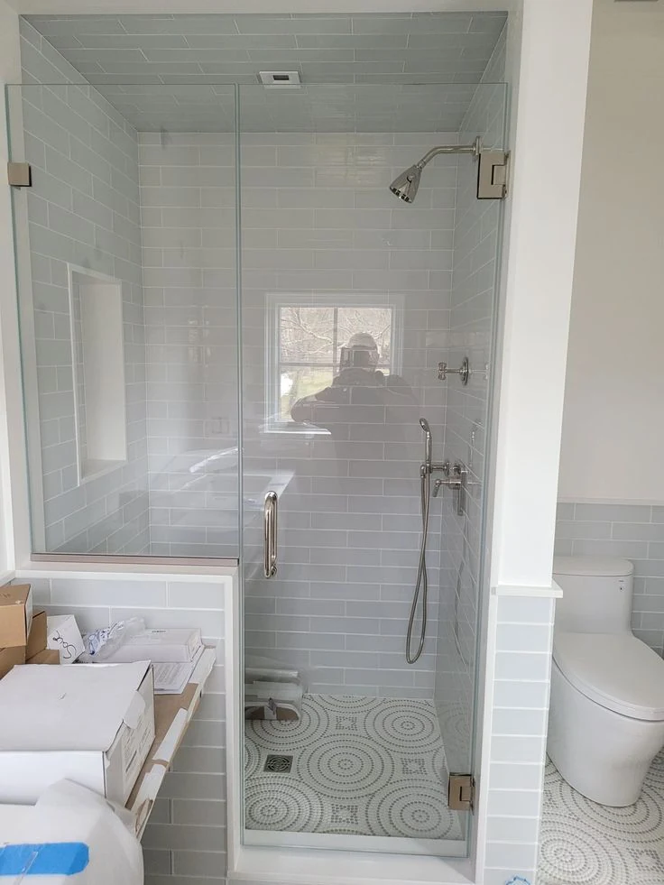 A shower enclosure against tiled walls